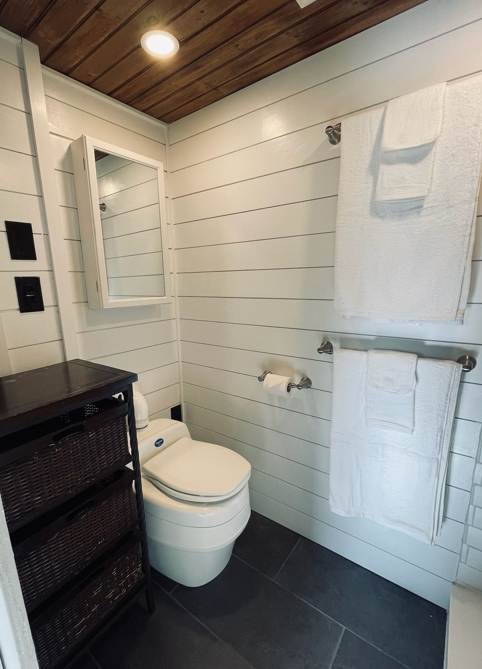 A bathroom with a white toilet, a mirror, and a towel rack.