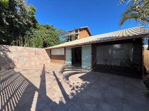Ein Wohnhaus mit überdachter Terrasse, Garage und gepflasterter Auffahrt.