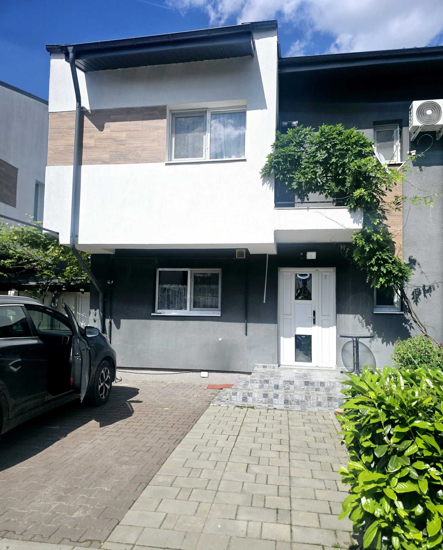 A modern two-story building with a car parked in front.