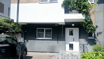 A modern two-story building with a car parked in front.