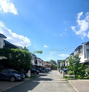 Eine Wohnstraße mit parkenden Autos, Häusern und blauem Himmel.