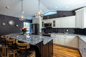 A modern kitchen with white cabinets, granite countertops, and stainless steel appliances. - 4-bedroom house with pool and hot tub.  Walking distance to downtown Spearfish. (Spearfish)