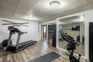 A home gym with treadmills, a stationary bike, and a mirror. - 4-bedroom house with pool and hot tub.  Walking distance to downtown Spearfish. (Spearfish)