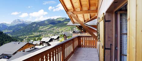 Un balcón de madera con vistas a un paisaje montañoso.