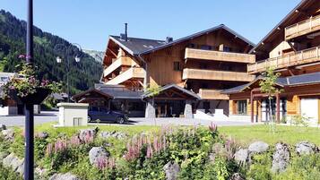 Ein Holzhaus mit mehreren Balkonen, einer Stein-Fassade und freiem Blick auf die umliegende Landschaft.