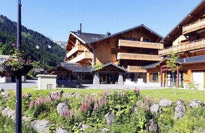 Un bâtiment en bois doté de nombreux balcons, d’une façade en pierre et offrant une vue dégagée sur le paysage environnant.
