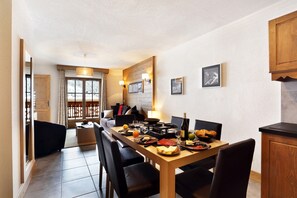 Un espace repas comprenant une longue table, des chaises et une variété de plats.