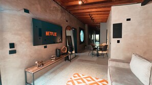 Ein modernes Interieur mit einem Netflix-Schild, einem Rundfenster und einem Essbereich.
