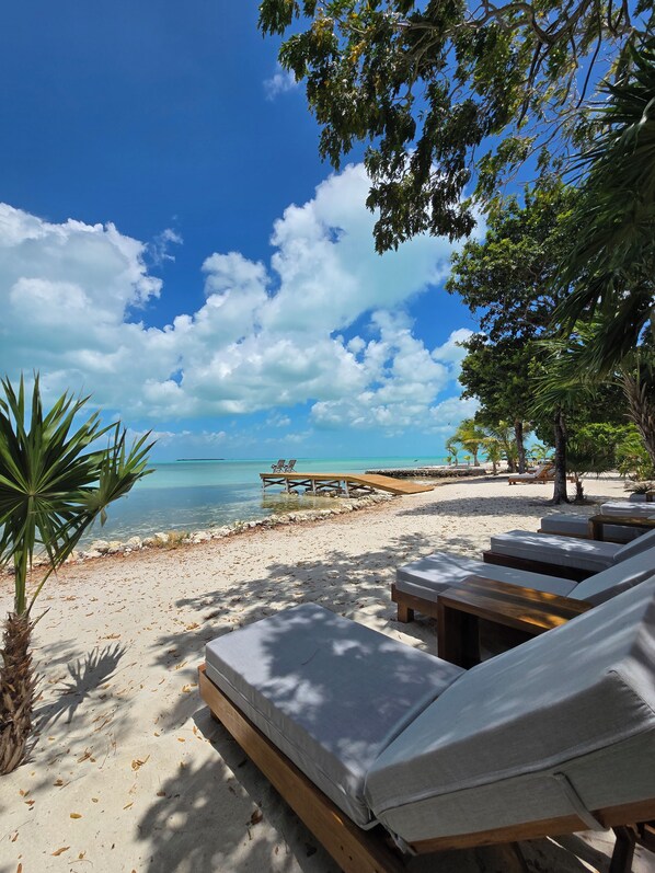 A beachside resort with lounge chairs, a wooden deck, and a clear view of the ocean. - Ix Chel Wellness Resort (San Pedro)