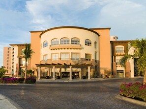 A hotel with a curved facade, multiple balconies, and a covered entrance area. - One Bedroom Suite at Villa del Palmar Cabo San Lucas (Cabo San Lucas)
