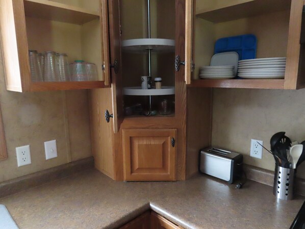 A kitchen with a built-in microwave, a toaster, and a spice rack.