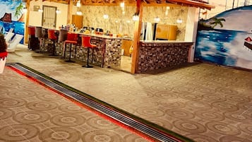 A small outdoor bar with a tiled floor and a red roof.
