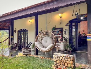 A cozy interior with a hanging chair, a sign for a museum, and a rustic stone wall.
