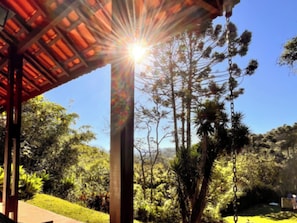 A covered outdoor area with a swing, surrounded by trees and a clear sky. - VELINN Pousada Lua e Sol (Santo Antônio do Pinhal)