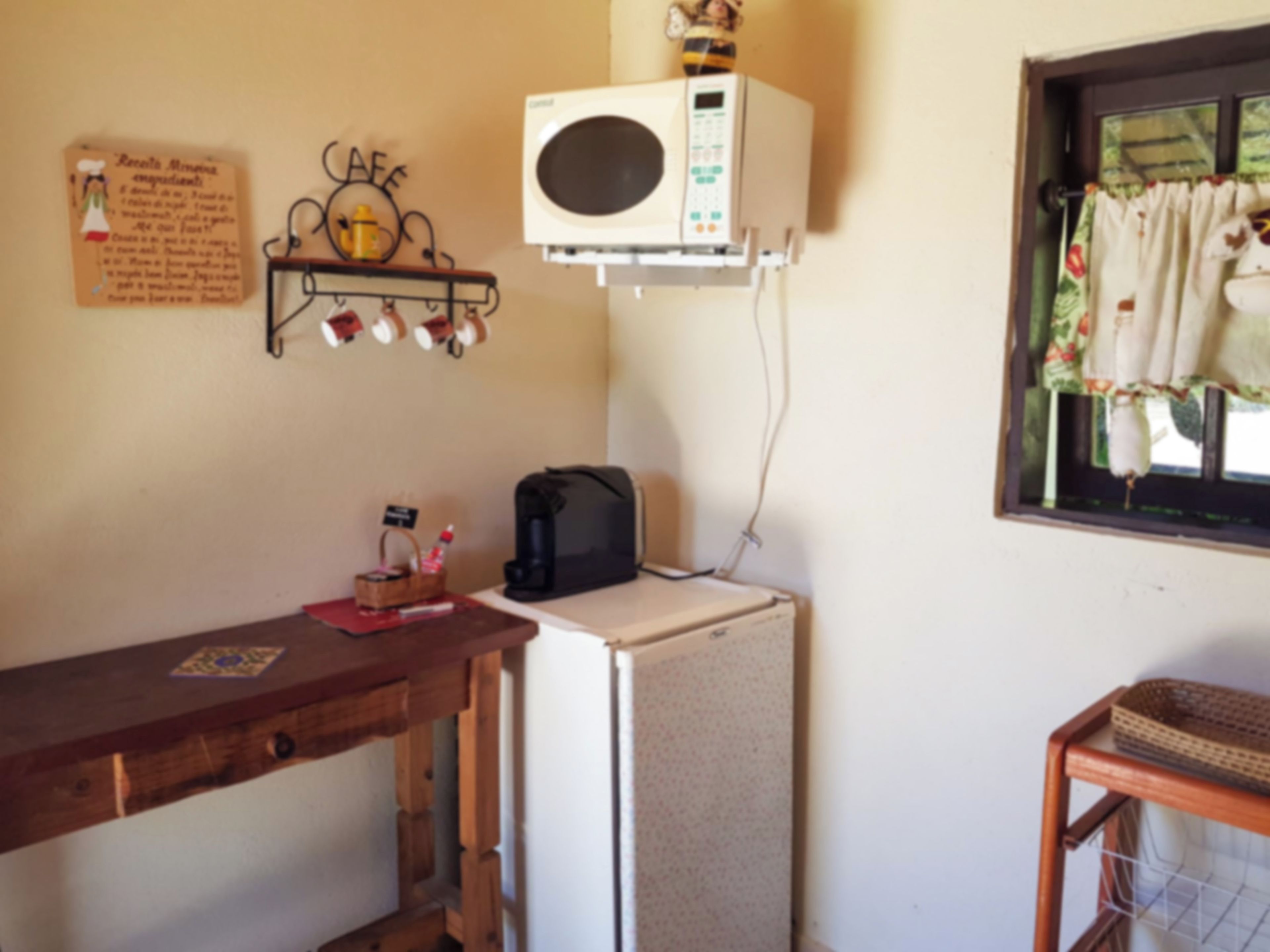 Una kitchenette equipada con refrigerador, cafetera y aire acondicionado de pared.