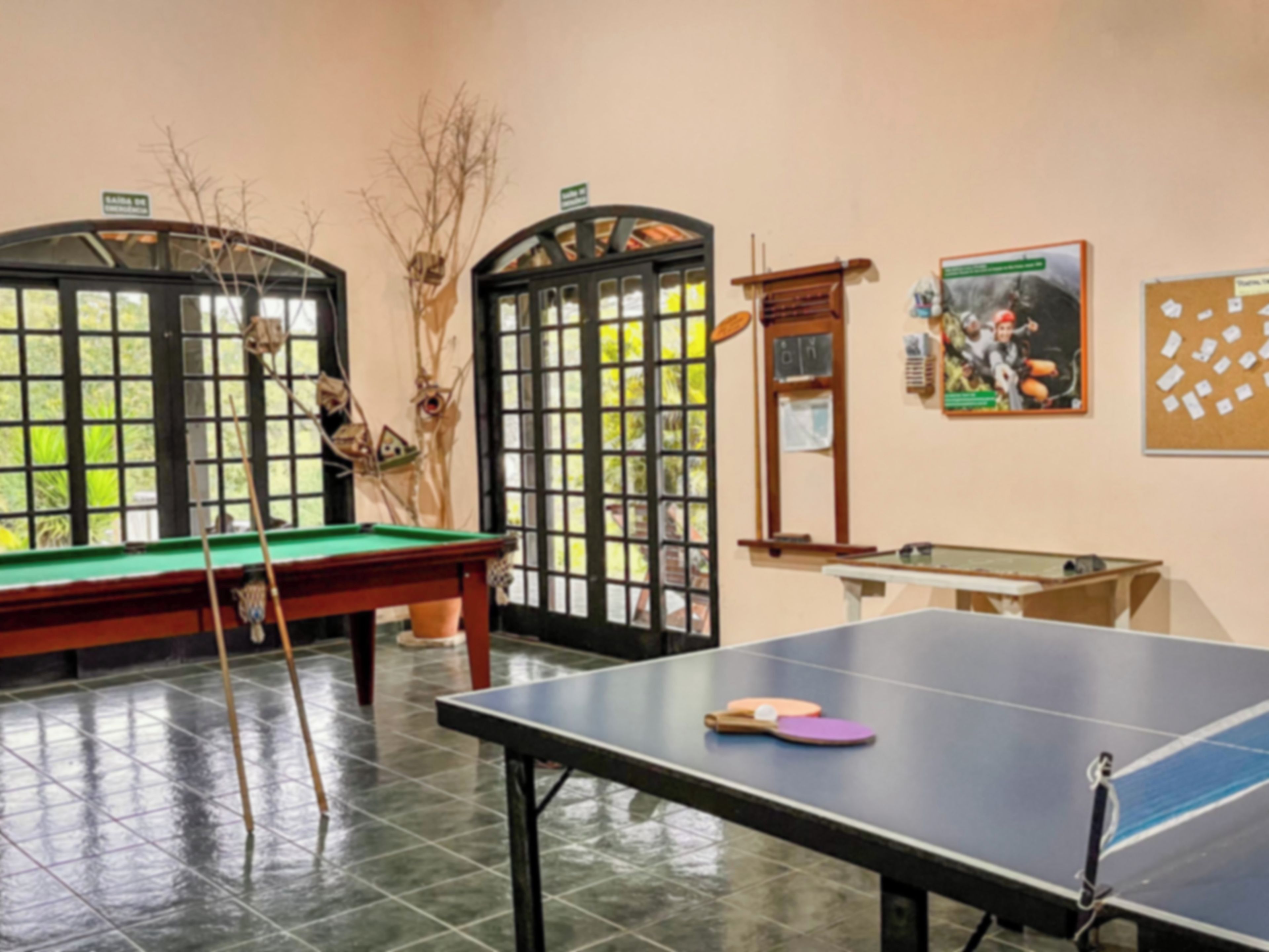 Una mesa de billar con tacos, mesa de pool y un cartel en la pared.