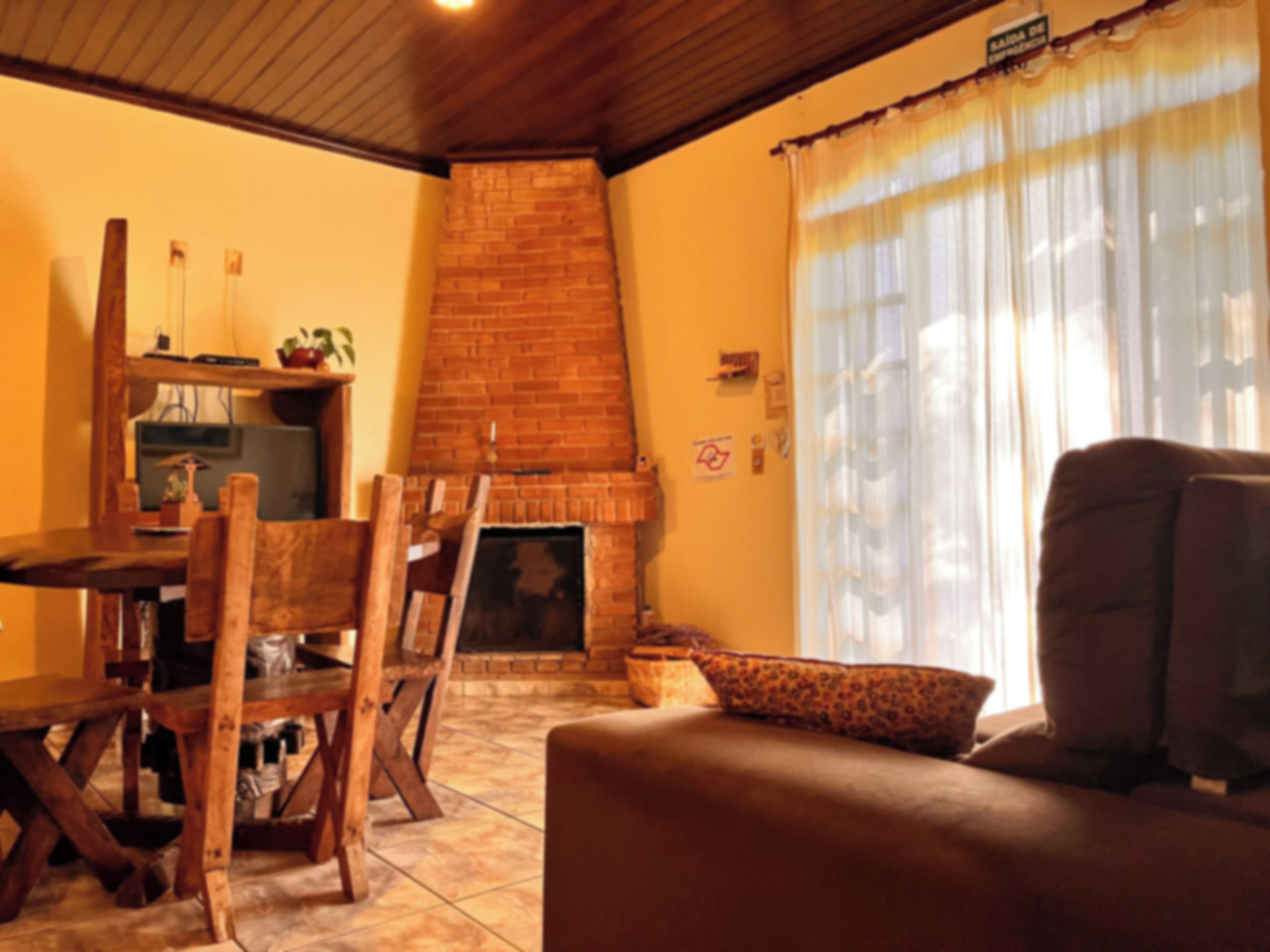 Ein gemütliches Wohnzimmer mit Kamin, Holzmöbeln und einer Couch.