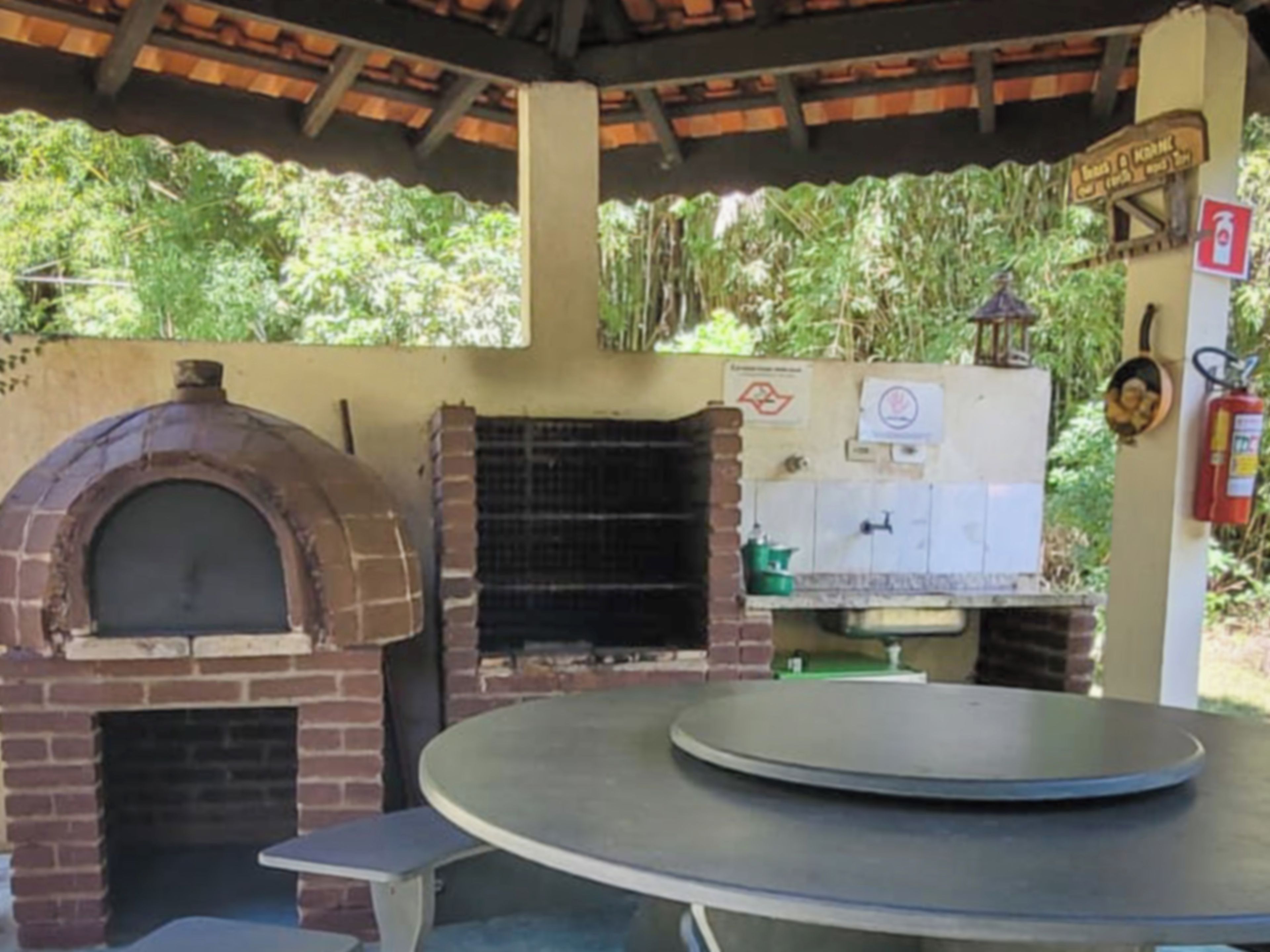 Un horno de ladrillo y una mesa con tapa circular, posiblemente para preparar o servir alimentos.