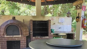 Un horno de ladrillo y una mesa con tapa circular, posiblemente para preparar o servir alimentos.