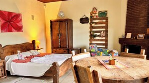 Una habitación acogedora con una cama de madera, una mesa de comedor y una chimenea.