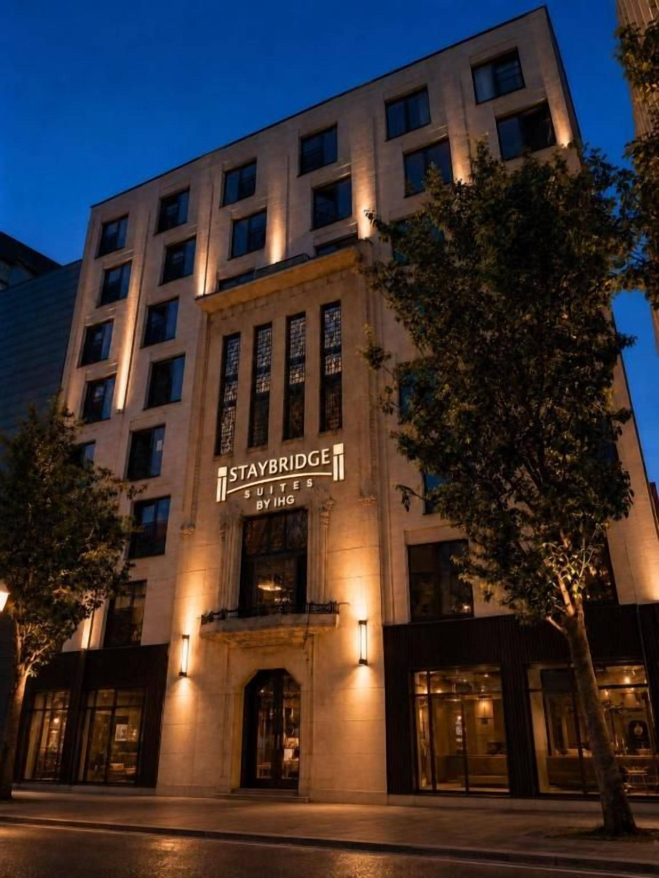 A multi-story hotel with a prominent entrance and illuminated signage.