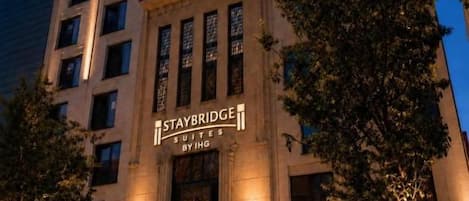 A multi-story hotel with a prominent entrance and illuminated signage.
