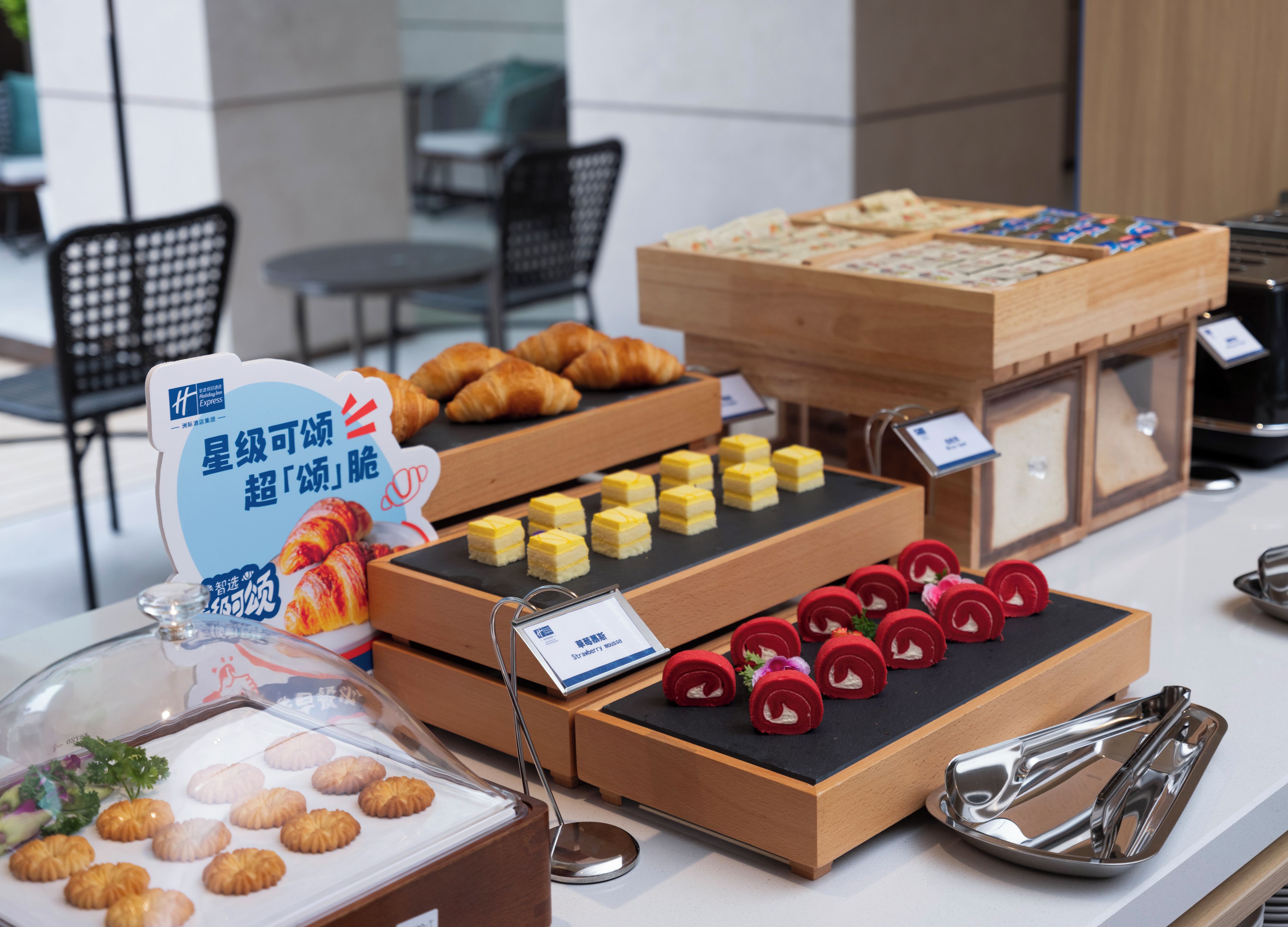 A buffet with various food items including pastries, desserts, and a sign indicating a special offer.