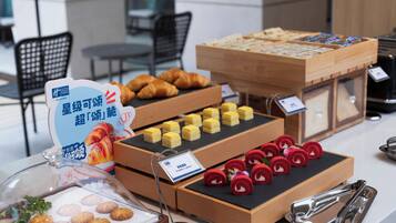 A buffet with various food items including pastries, desserts, and a sign indicating a special offer.