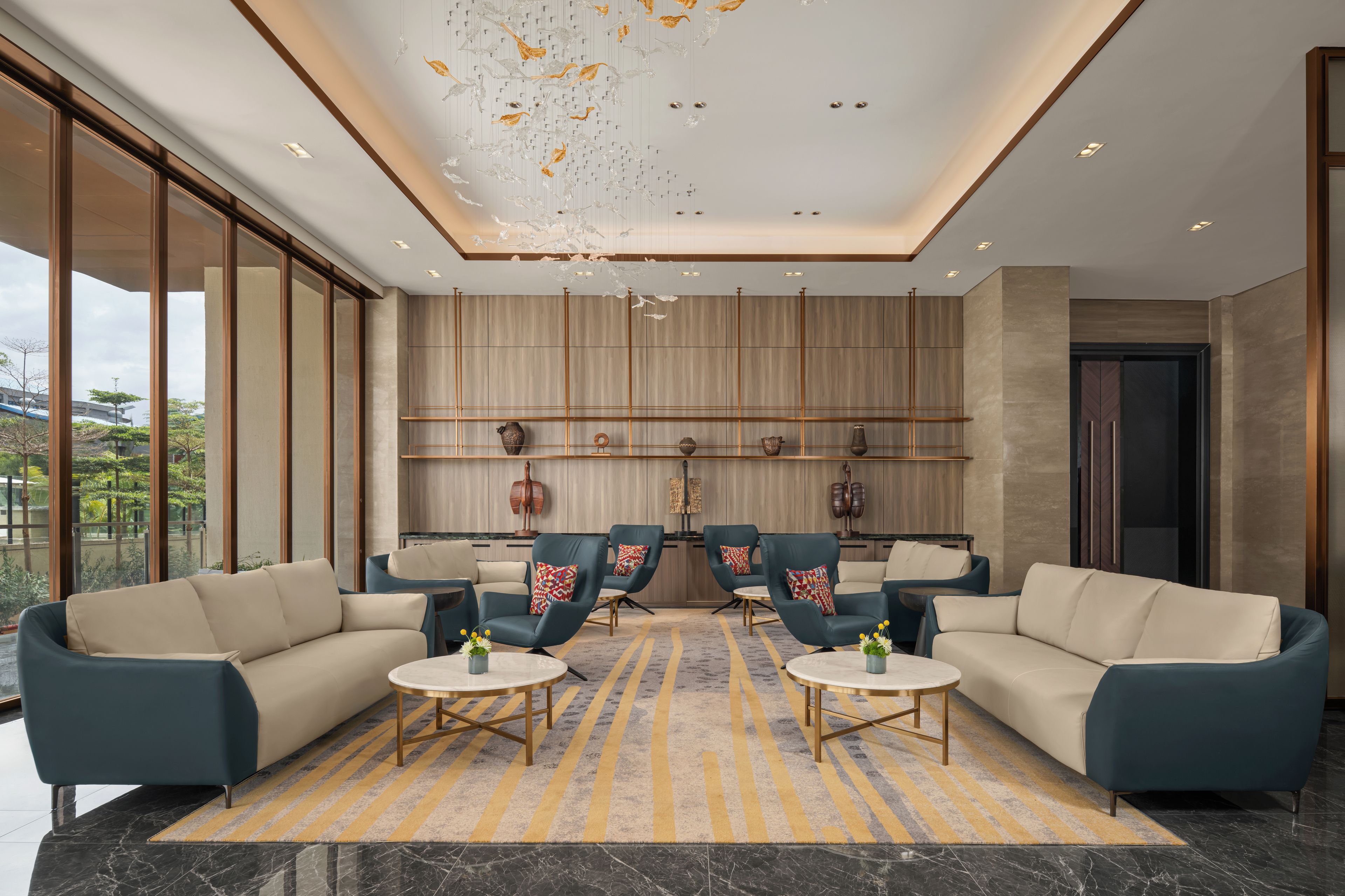 A modern lounge area with sofas, armchairs, and a patterned rug.
