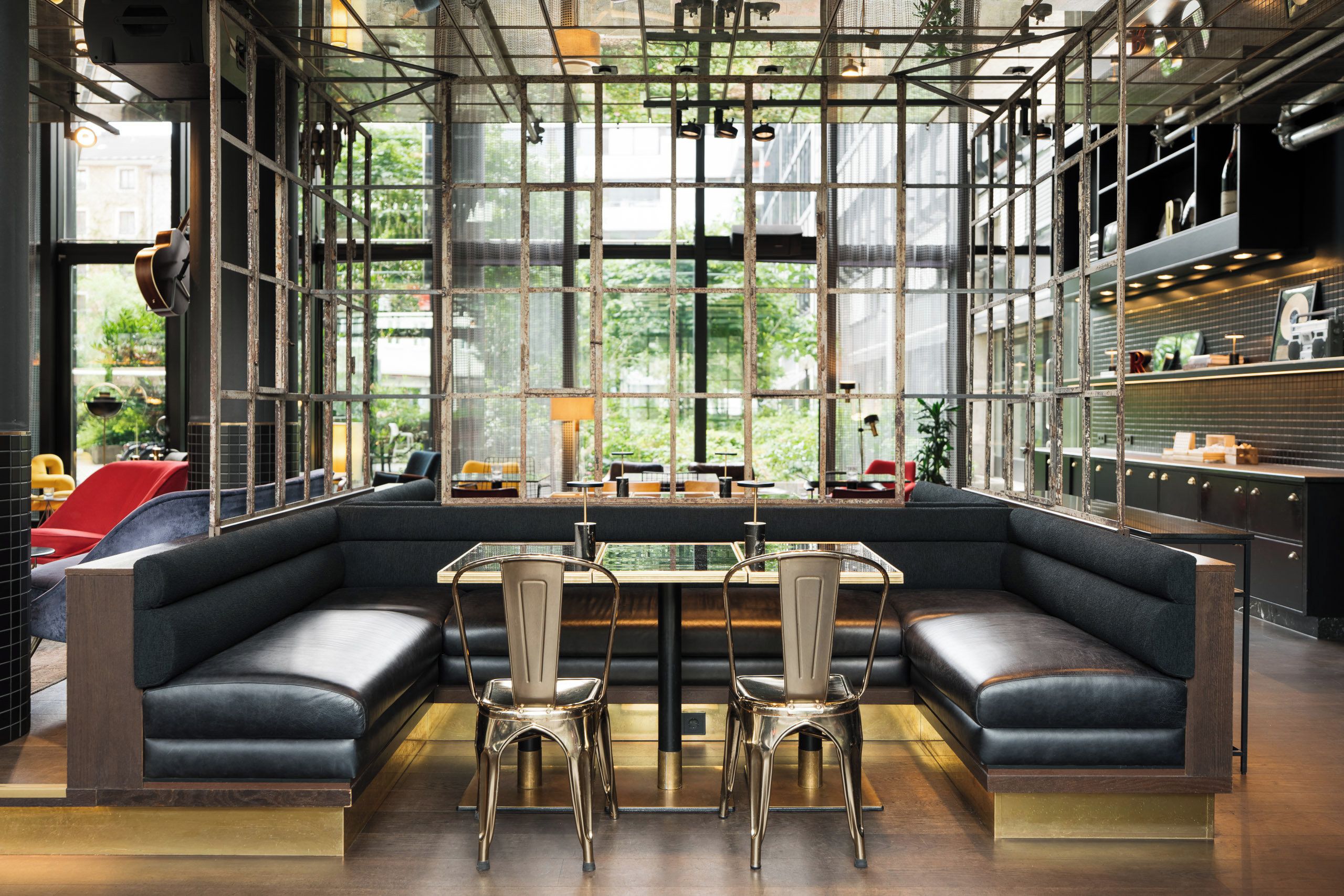 A modern interior with a glass partition, leather seating, and a bar area.