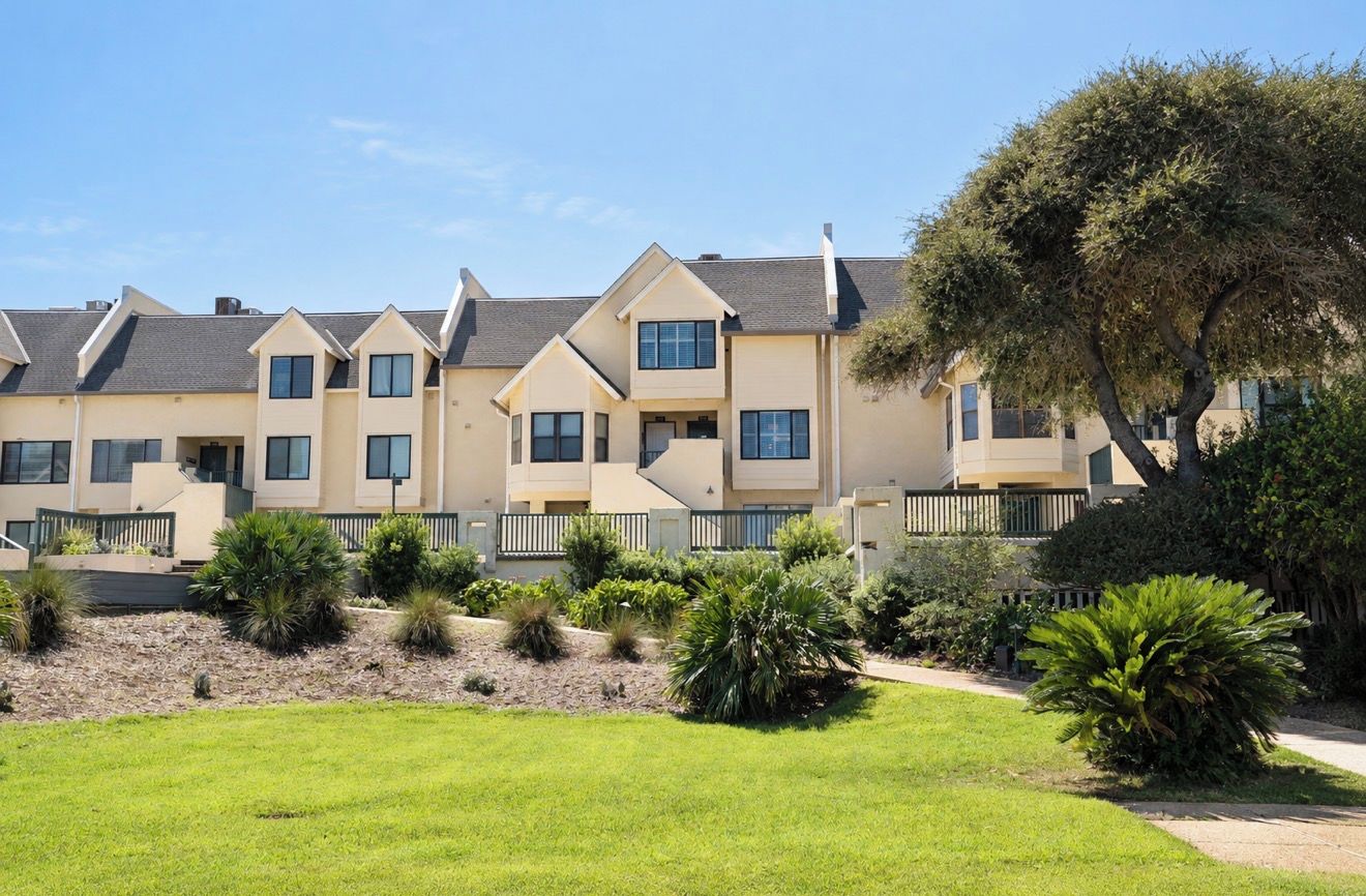 A row of modern two-story houses with a well-maintained lawn and landscaping.