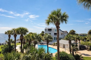 Ein Resort mit Pool, Palmen und Meerblick.