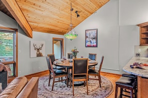 A dining area with a round table, chairs, and a chandelier. - Abode at Winterhaven, hot tub pool, Deer Valley (Park City)