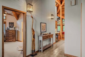 A hallway with wooden beams, a fireplace, and wall-mounted sconces. - Abode at Winterhaven, hot tub pool, Deer Valley (Park City)