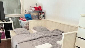 Ett sovrum med en säng, ett skrivbord och en byrå.