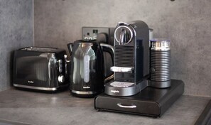 Eine Küchenarbeitsplatte mit einem Toaster, einer Kaffeemaschine, einem Wasserkocher und einer Tasse.