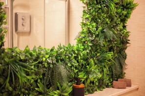 A bathroom with a vertical garden wall, a shower area, and a towel rack. - NEW - Cosy Studio in Glasgow's City Centre (Glasgow City)