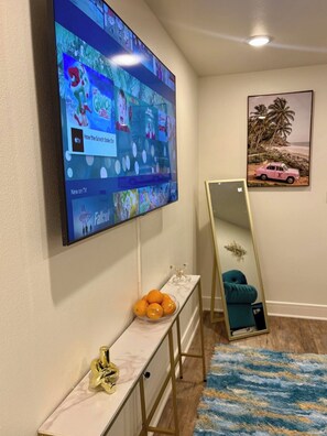 Un salon avec un téléviseur à écran plat fixé au mur, diffusant un film de Noël.