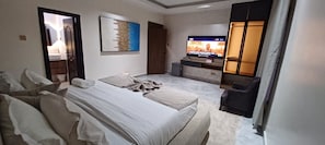 Une chambre d’hôtel avec un lit, une télévision, un bureau et une chaise.