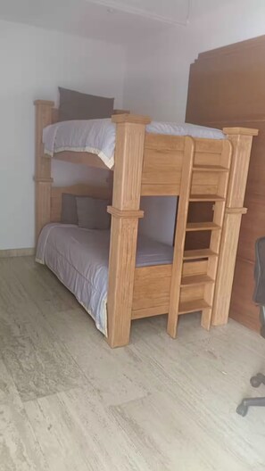 A bunk bed with a wooden frame and a grey mattress. - Loft Acapulco Diamante / Club de Playa / canchas (Acapulco de Juárez)