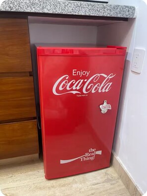 A red refrigerator with the Coca-Cola logo and slogan 'Enjoy Coca-Cola' on it. - Loft Acapulco Diamante / Club de Playa / canchas (Acapulco de Juárez)