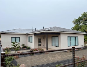 A modern two-story house with a flat roof, large windows, and a covered porch. - 3-bedroom house in delightful Albuquerque Watch the Balloon Fiesta  on the porch (Albuquerque)