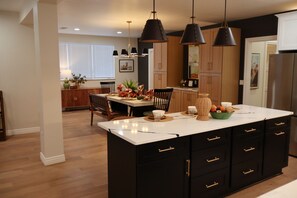 A modern kitchen with a central island, black cabinetry, and pendant lighting. - 3-bedroom house in delightful Albuquerque Watch the Balloon Fiesta  on the porch (Albuquerque)