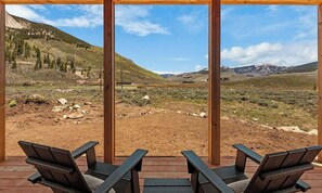 A wooden deck with two chairs facing a scenic view of a mountainous landscape. - The Brush Creek Lookout - Home Away From Home (Crested Butte)