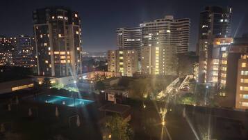 A nighttime view of a hotel complex with multiple high-rise buildings, a swimming pool, and well-lit streets.