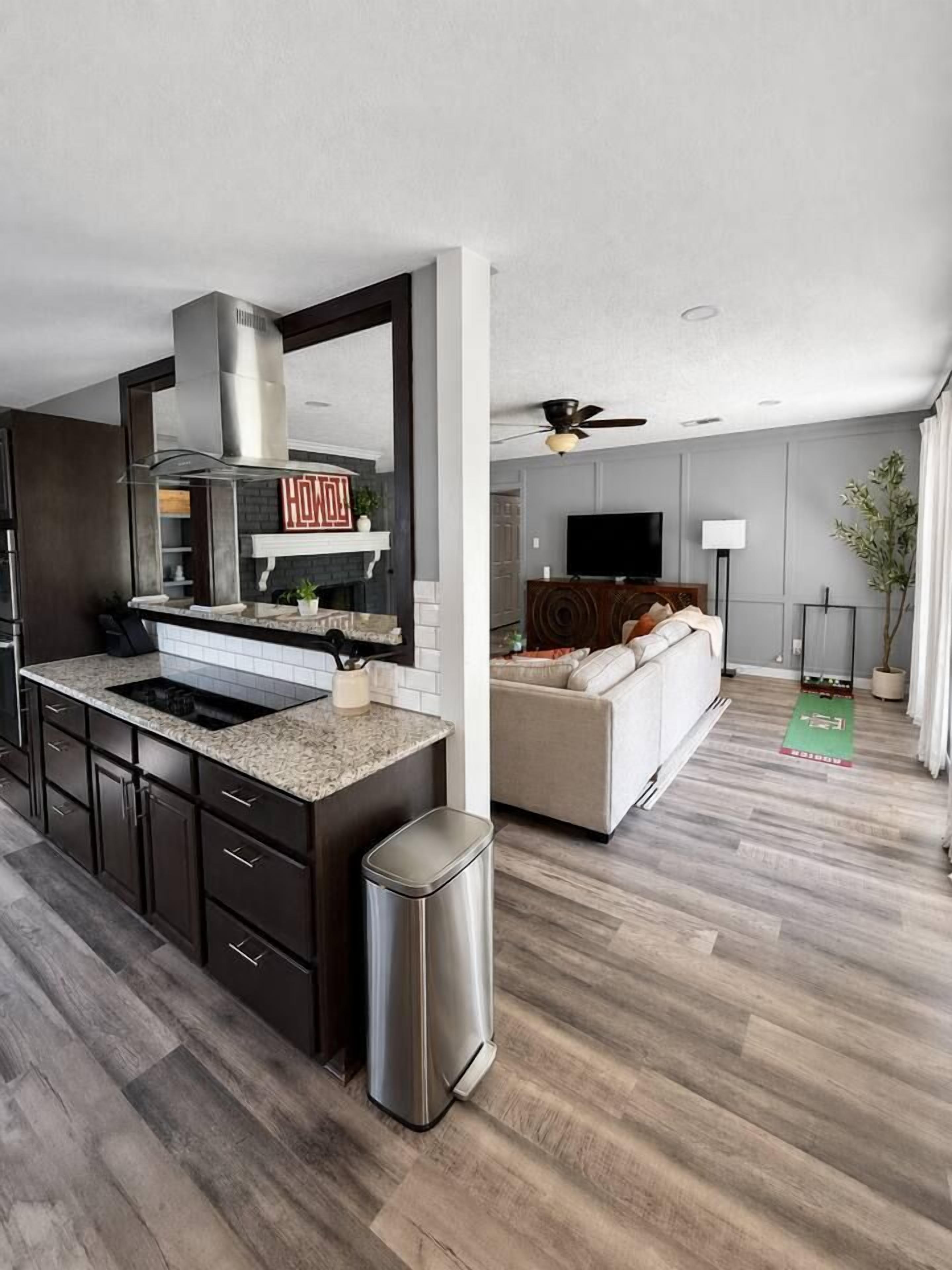 A modern kitchen with a built-in stove, a large island, and dark cabinetry.