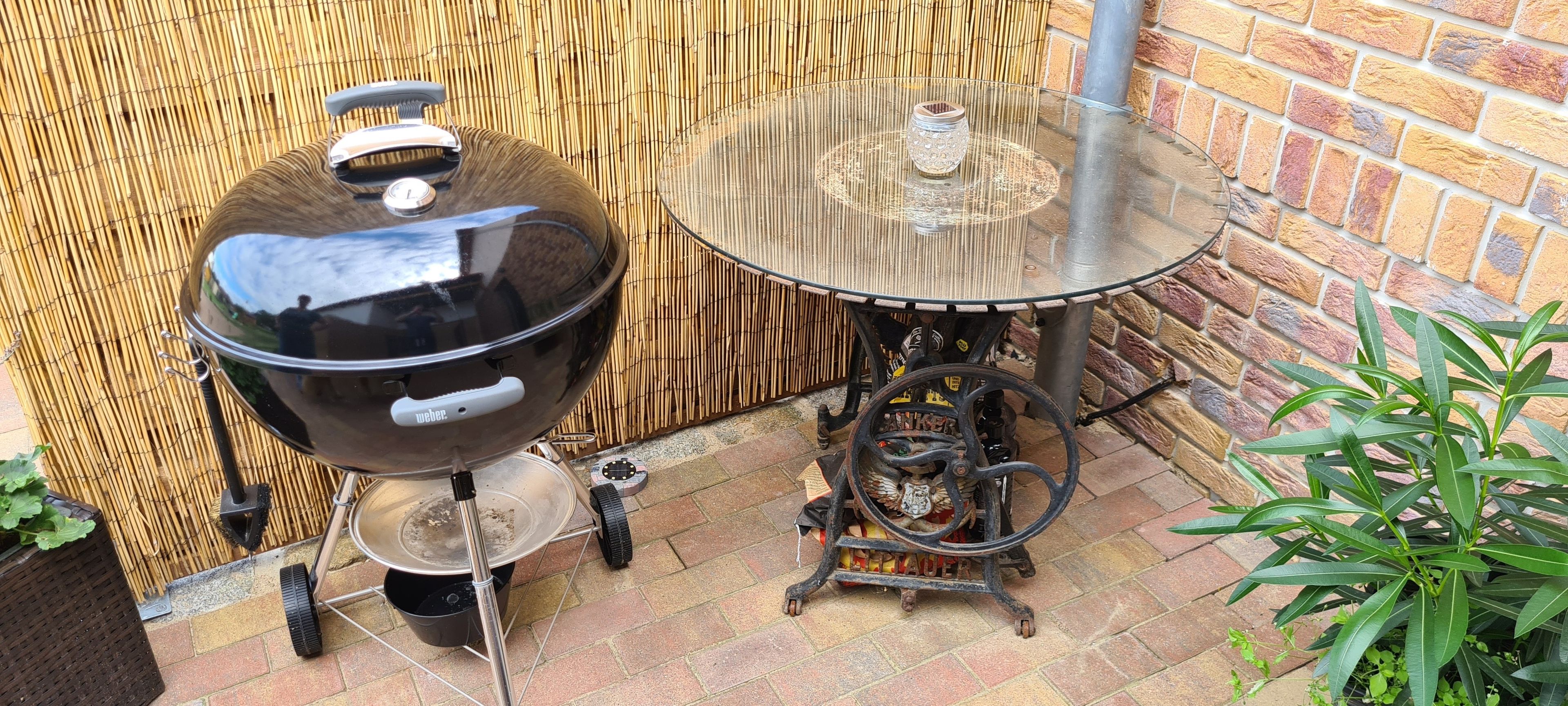 Ein Weber-Grill mit Seitentisch und einem tragbaren Gasherd.