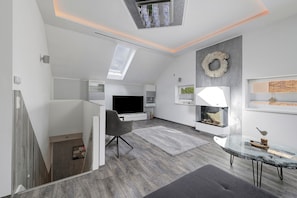 A modern interior with a skylight, a fireplace, and a television.