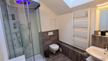 Ein modernes Badezimmer mit Duschkabine, Toilette, Waschbecken und Spiegel.