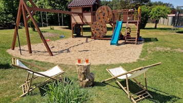 Ein Spielplatz mit Schaukeln, Rutschen und Klettergerüsten.